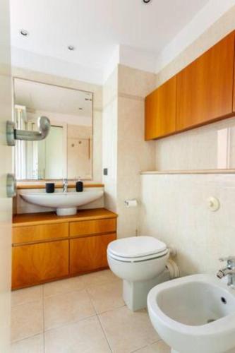 a bathroom with a white toilet and a sink at Home & Pet - Parco in Basiglio