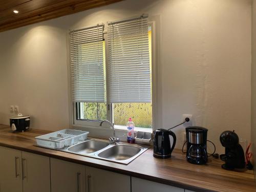 eine Küchentheke mit einem Waschbecken und einem Fenster in der Unterkunft L'écho de la montagne in Cilaos