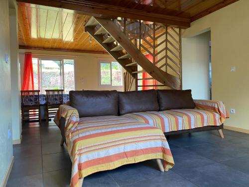 a couch in a living room with a wooden ceiling at L'écho de la montagne in Cilaos