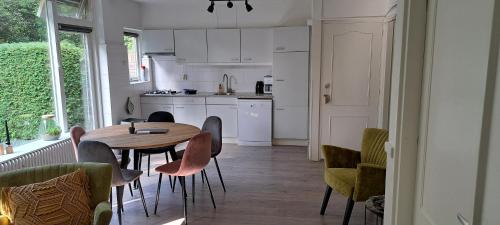 a kitchen and dining room with a table and chairs at Knusse 5 Persoons Bungalow Hartje Veluwe in Otterlo