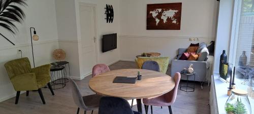 a living room with a wooden table and chairs at Knusse 5 Persoons Bungalow Hartje Veluwe in Otterlo