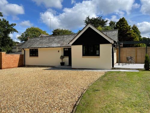 a detached house with a gravel driveway at Springfield Lodge - Adorable New Forest 1-bedroom guest house in Ringwood