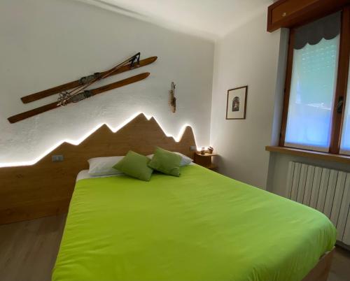 Una cama verde con dos almohadas encima. en BoTép ai Tigli, en San Pellegrino Terme