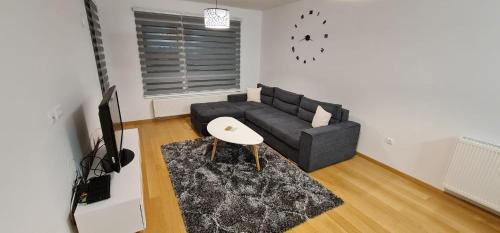 a living room with a black couch and a table at Whitehouse apartment in Bjelašnica
