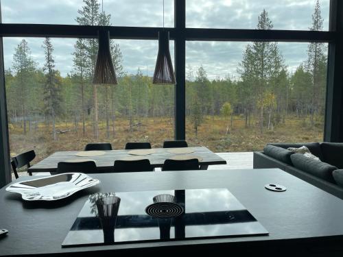 a dining room with a table and a large window at Villa JoenPolku Ruka in Ruka
