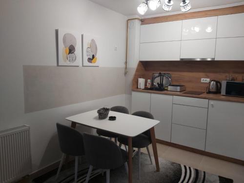 a kitchen with a table and chairs in a room at Whitehouse apartment in Bjelašnica