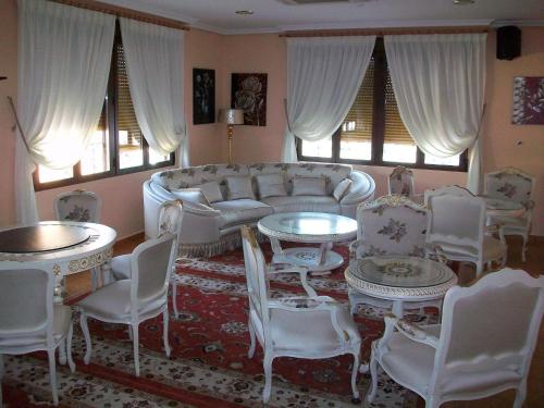 a living room with a couch and tables and chairs at Hotel Flor de la Mancha in La Roda