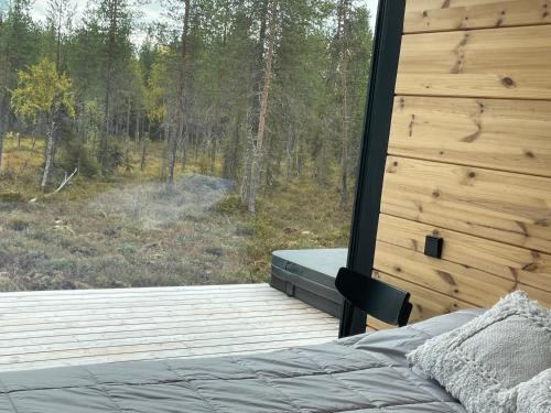 a bedroom with a bed and a view of a forest at Villa JoenPolku Ruka in Ruka