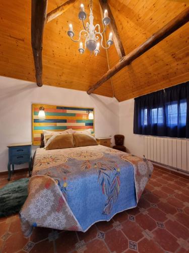 a bedroom with a large bed with a wooden ceiling at Casa Flora - Casa rural con encanto in El Carpio de Tajo