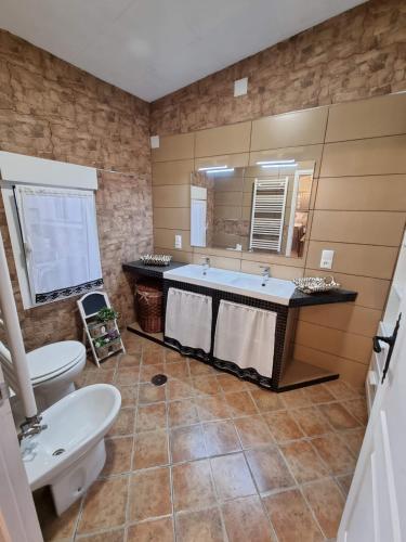 baño con lavabo y espejo grande en Casa Flora - Casa rural con encanto, en El Carpio de Tajo