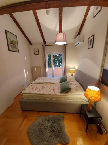 a bedroom with a bed and a window and a lamp at Apartment Sun view in Mali Lošinj