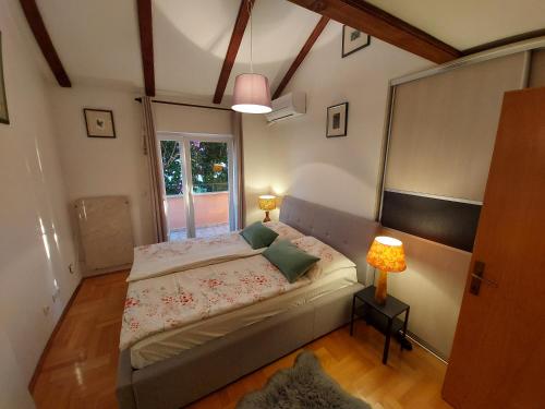 a small bedroom with a bed and a window at Apartment Sun view in Mali Lošinj