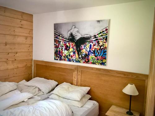 レ・キャローズ・ダラッシュにあるAppartement cosy 4-6 personnes aux carroz d Arrachésの壁に絵画が飾られた部屋のベッド2台