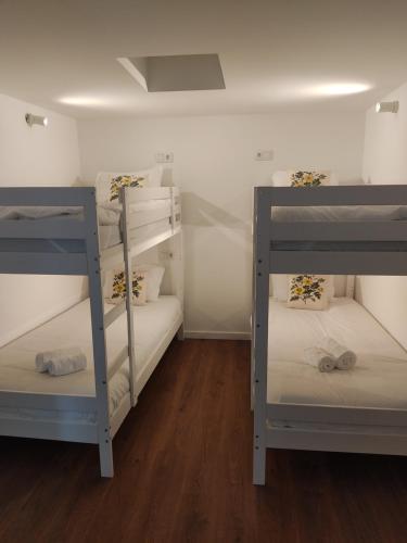 two bunk beds in a room with wooden floors at Hotel Rural Solar das Arcadas in Ponte de Lima