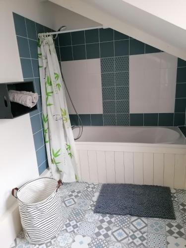 - une salle de bains avec baignoire et un panier à l'étage dans l'établissement Moana, à Honfleur
