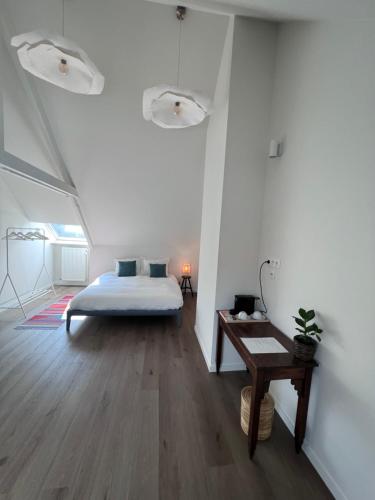 a bedroom with a bed and a wooden floor at Maison Georges in Turnhout