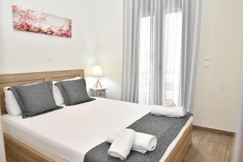 a bedroom with a large white bed with towels on it at Michaela's guesthouse in Nafplio