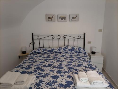 um quarto com uma cama azul e branca com toalhas em La Cameretta em Barisciano