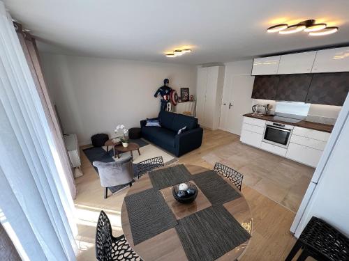uma sala de estar com uma mesa e um sofá em Appartement 6 pers Val d'Europe - Disneyland Paris - Captain America em Chessy