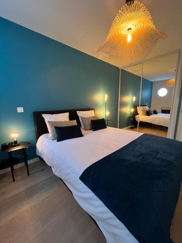 a bedroom with a large bed with a blue wall at Appartement 6 pers Val d'Europe - Disneyland Paris - Captain America in Chessy