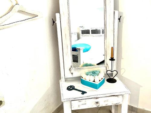 a mirror on a white table with a blue box at Oia Sunset House Pothitou in Oia