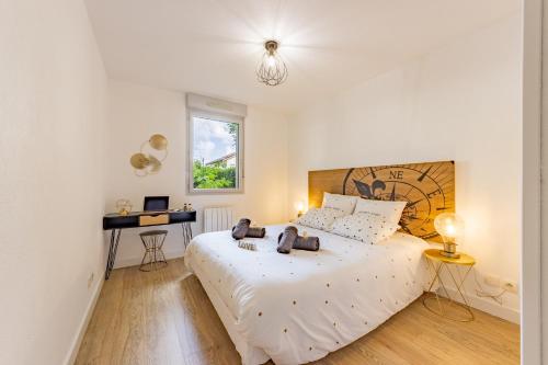 a bedroom with a large white bed and a desk at To Be Discovered L'escapade Cosy in Pradines