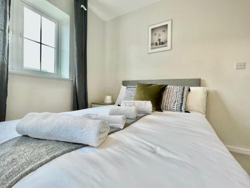 een wit bed met handdoeken in een slaapkamer bij 3 bedroom lovely apartment in Slough with free parking in Farnham Royal