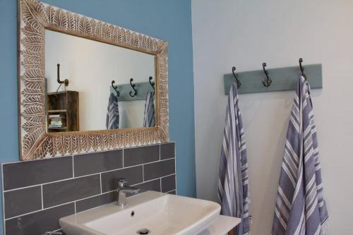 a bathroom with a sink and a mirror at Seafront house with a view in Kleinmond