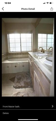 a bathroom with two sinks and a bath tub at Pacific Breeze Right Next to Huntington Beach Pier! Steps from Beach!! in Huntington Beach