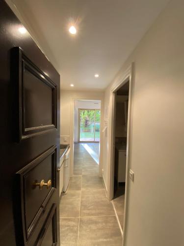 un couloir avec une porte menant à une cuisine équipée d'une télévision dans l'établissement Studio deauville Situé devant la plage, à Deauville