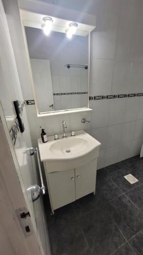 een badkamer met een witte wastafel en een spiegel bij Duplex Donovan in Resistencia