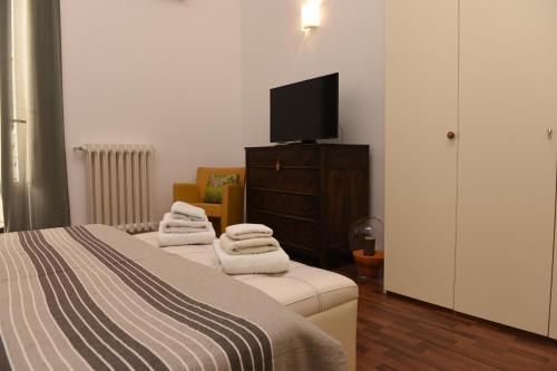 een slaapkamer met 2 bedden en een televisie op een dressoir bij La Casetta di Vale in Taranto