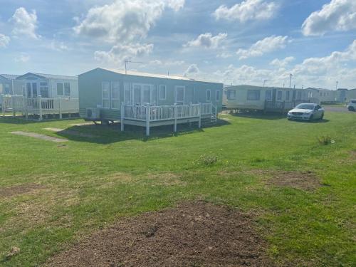 a row of houses with a car parked in a field at A7 caravan The Chase Ingoldmells in Ingoldmells