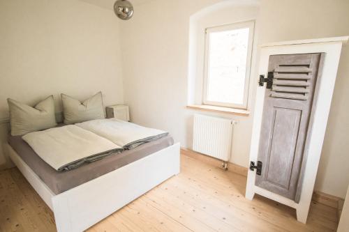 ein weißes Bett in einem Zimmer mit Fenster in der Unterkunft Ferienwohnung Schwalbennest in Kiebitz