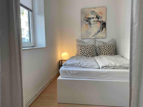 a white bedroom with a bed with a window at Apartment Strauss #EINS 1,5 Zi BS-östliches Ringgebiet in Braunschweig