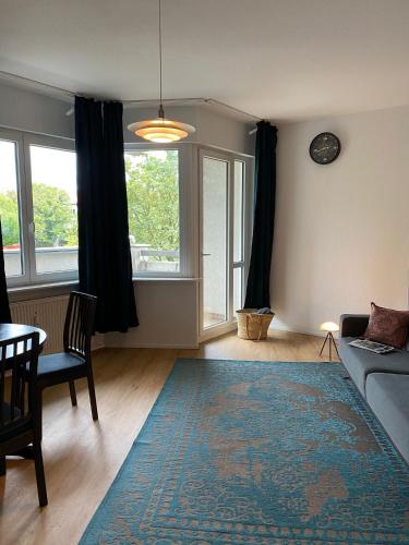 ein Wohnzimmer mit einem Sofa und einem Tisch in der Unterkunft Beautiful apartment with balcony in Berlin
