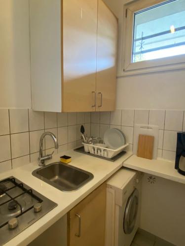 a small kitchen with a sink and a window at Beautiful apartment with balcony in Berlin