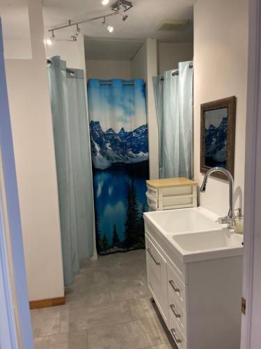 a bathroom with a shower with a mountain shower curtain at AUBERGE et BISTRO NAMASTÉ in Lachute