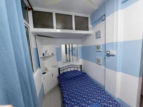 a small blue and white room with a bed at La Rêverie Apartment in Trou aux Biches
