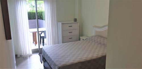 um quarto com uma cama, uma cómoda e uma janela em Precioso apartamento con dos terrazas privadas em Sant Jordi