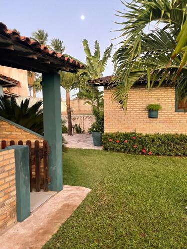MataracaにあるBarra Adventure Pousadaのレンガ造りの建物と緑のポールのある裏庭