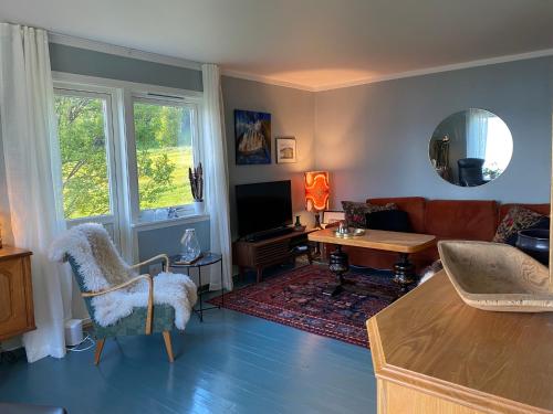 a living room with a couch and a table at Unique and charming holiday home with fantastic sea views in Tromsø