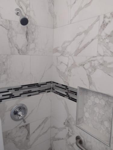 bagno con doccia e pareti in marmo bianco di Sky Fresh Home Stay ad Apple Valley