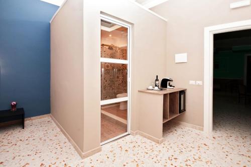 um quarto com uma porta de vidro que leva a uma casa de banho em "S. Cecilia" em Messina