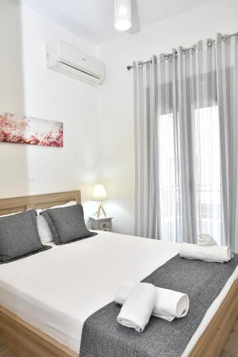 1 dormitorio con 1 cama blanca y 2 toallas en Michaela's guesthouse, en Nauplia