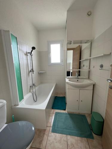 une salle de bain blanche avec une baignoire et un lavabo dans l'établissement Superbe appartement en résidence avec piscine proche plage, à Linguizzetta