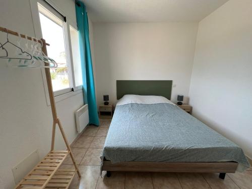 une petite chambre avec un lit et une fenêtre dans l'établissement Superbe appartement en résidence avec piscine proche plage, à Linguizzetta