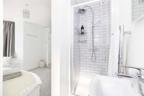 a white bathroom with a shower and a sink at The White House - Lux Southbourne beach 3 bed stay in Southbourne