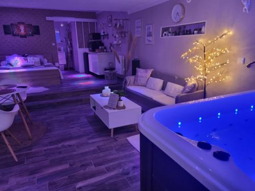 sala de estar con sofá y bañera en Chambres d'hôtes avec jacuzzi privatif en Westrehem