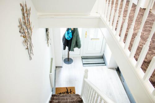 a staircase in a house with a coat on the door at Spacious 5-Bedroom Home - Sleeps 11 & Free Parking in Tilbury